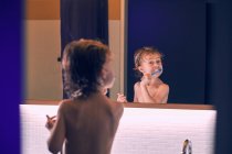 Carino bambino in piedi in bagno e lavarsi i denti a casa
. — Foto stock