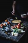 Erntehelferin legt Pudding auf Torte am Tisch — Stockfoto