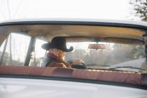Бородатий чоловік в капелюсі водіння автомобіля задній — стокове фото