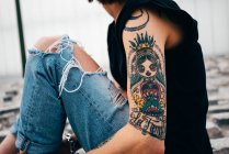 Crop donna tatuata seduto sul marciapiede — Foto stock