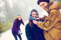 Group laughing friends playing snowballs in woods — Stock Photo