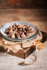 Stillleben von Schokoladentrüffeln im rustikalen Keramikteller auf dem Tisch — Stockfoto