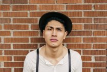 Serene man in hat posing at brick wall — Stock Photo