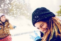 Sorridente donna nascondendo il viso dalla palla di neve all'aperto — Foto stock