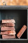 Close up view of stacked chocolate bars in wooden box — Stock Photo