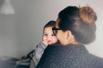 Adorable boy on mother hands looking at camera — Stock Photo