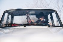 Человек в шляпе регулирует зеркало заднего вида автомобиля — стоковое фото