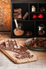 Mesa com vários chocolates e trufas na placa — Fotografia de Stock