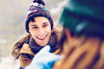 Hombre alegre mirando a la mujer en invierno al aire libre - foto de stock