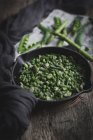 Still life of pan full of green peas on rustic table — Stock Photo