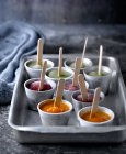 Metal tray with cups filled with various fruit ice pops on table. — Stock Photo