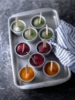 Bandeja de metal con copas llenas de helado de frutas en la mesa . - foto de stock