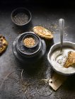 Yogur con galletas y surtido de semillas en mesa rural - foto de stock