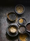 Nature morte de diverses graines dans des bols sur une table en pierre — Photo de stock