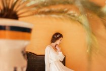 Vue latérale de la femme en robe blanche assise sur le banc — Photo de stock