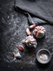 Stillleben von Knoblauch und Salz auf Steinoberfläche — Stockfoto