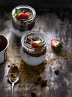 Pots aux fraises et chocolat sur table en bois — Photo de stock