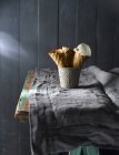 Натюрморт з вафельними шишками в кухольці на сільському столі — стокове фото