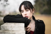 Melancholische Frau in Schwarz lehnt an Zaun — Stockfoto