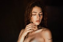 Sensual topless girl keeping eyes closed and touching face gently. — Stock Photo