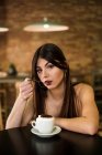 Femme assise dans un café avec du café — Photo de stock