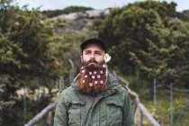 Homme avec des fleurs à la barbe — Photo de stock