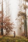 Mulher de pé na floresta nebulosa — Fotografia de Stock