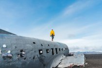 Giovane senza volto che cammina sulla carcassa di aerei abbandonati mentre viaggia attraverso l'Islanda — Foto stock
