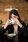 Donna seduta in caffè con caffè — Foto stock