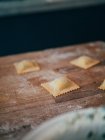 Raw ravioli on wooden board — Stock Photo