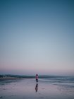 Femme marchant sur la plage de sable — Photo de stock