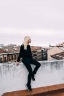 Femme blonde assise sur le toit — Photo de stock
