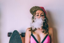 Mujer patinadora fumando un porro de cannabis - foto de stock
