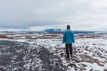 Людина стоїть на віддаленому сніжному полі — стокове фото