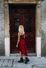 Mujer de pie frente a la vieja puerta - foto de stock
