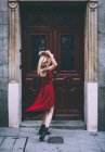 Femme debout devant la vieille porte — Photo de stock