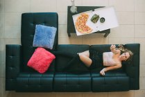 Donna sdraiata sul divano con canna di marijuana — Foto stock