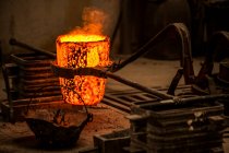 Schnittansicht eines Mannes in Arbeitskleidung, der mit brennendem Feuer Kohlen im Ofen verhindert — Stockfoto