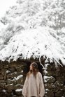 Frau steht an Hütte im Winterwald — Stockfoto