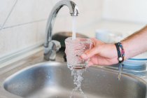 Hand washing glass in sink — Stock Photo