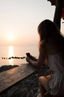Frau mit Smartphone am Meer — Stockfoto
