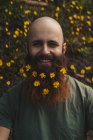 Mann mit Blumen im Bart — Stockfoto