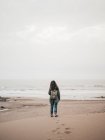Woman with backpack at ocean — Stock Photo