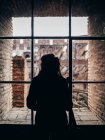 Person blickt aus Fenster auf Ruinen — Stockfoto