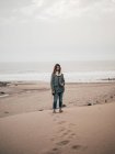 Женщина, стоящая на берегу океана — стоковое фото