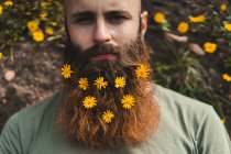 Mann mit Blumen im Bart — Stockfoto
