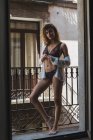 Woman in stylish underwear standing on balcony — Stock Photo