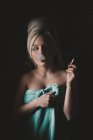 Жінка, загорнута в рушники, курить сигарету — стокове фото