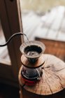 Versando acqua in brocca con caffè — Foto stock