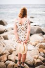 Woman with hat standing on rocks — Stock Photo